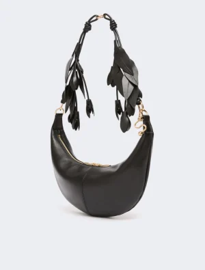Black crescent-shaped leather handbag with gold hardware and a decorative leaf-strap.