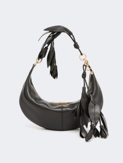 Black leather hobo shoulder bag with gold hardware and fringe tassels hanging from the strap.