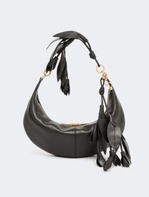 Black crescent-shaped leather handbag with gold hardware and dangling tassel fringe beneath the strap.
