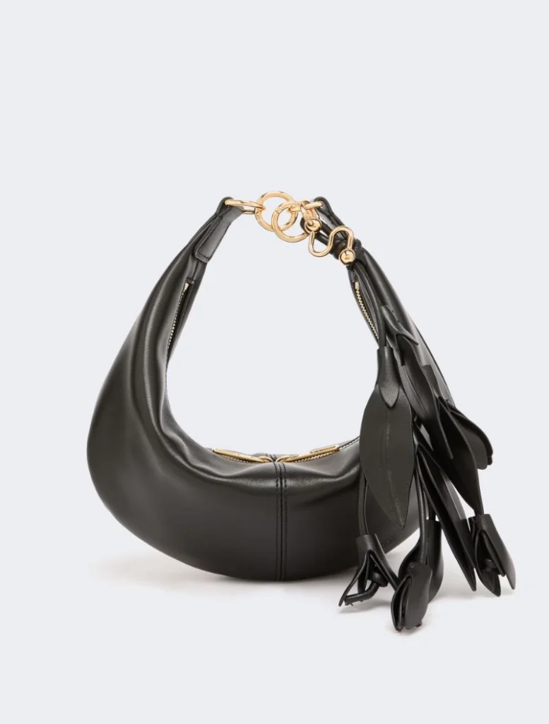 Black leather hobo bag with gold hardware and long tassel fringe on the side.