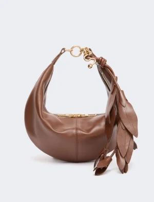 Brown leather hobo handbag with a gold zipper and oversized shoulder strap, featuring a decorative tassel on the side.