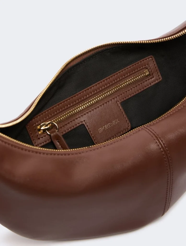 Brown leather handbag opened to reveal a gold-zippered inner pocket.