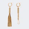Gold-tone tassel earrings with a long fringe on the left and a pearl drop with chain on the right