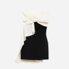 Black fitted strapless dress with a white draped top tied in a knot at the waist and cascading fabric