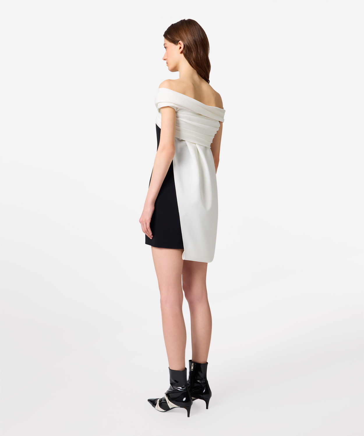 IMG_3187 - New Trend Model wearing a black and white color-block dress with an off-the-shoulder white draped top and black side panel, paired with black ankle boots.