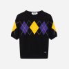Black knit sweater with a purple and yellow argyle motif across the chest and on the sleeves, short‑sleeve pullover with ribbed cuffs and hem.