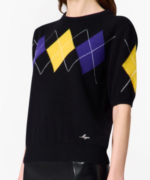 Black knit sweater featuring a multicolored argyle diamond pattern (yellow, purple) across the chest and along the sleeve with white crisscross lines, ribbed hem and short sleeves.