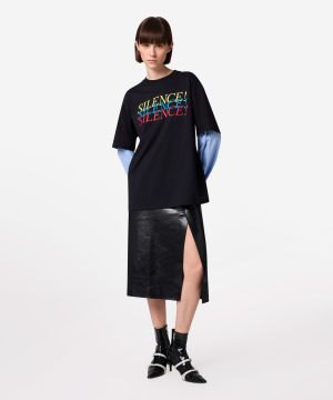 Model wearing a black T-shirt with a colorful 'SILENCE!' graphic, layered over a blue striped long-sleeve, paired with a black leather midi skirt with a side slit and black heeled boots.