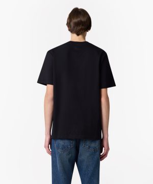 Back view of a person wearing a black short-sleeve tee and blue jeans; small MSGM logo on upper back.