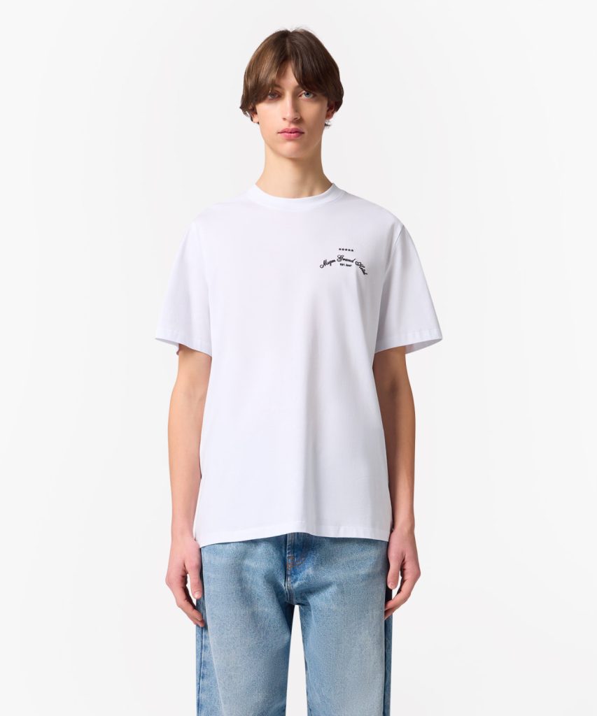 White short-sleeve T-shirt with small chest logo, modeled with light-wash jeans against a plain background
