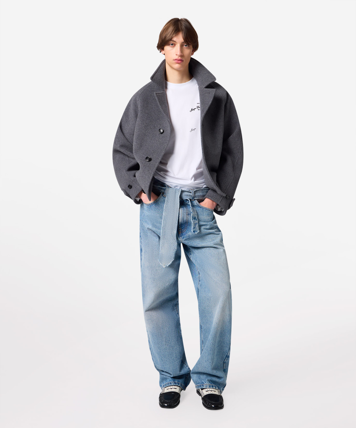 IMG_3253 - New Trend Model wearing an oversized gray coat over a white T-shirt and light-wash baggy jeans, standing with hands in pockets.