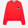Bright red crewneck sweatshirt with a small embroidered black cat on a white cushion patch on the chest, and a visible label at the neckline.