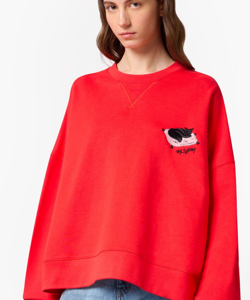 Red oversized sweatshirt on a model featuring a small embroidered panda on a pink cushion with the MSGM logo on the left chest.