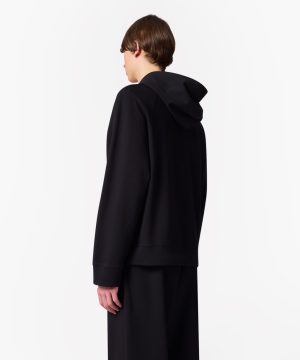 Person wearing a black hoodie, shown from the back against a white background.