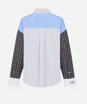 Back view of a color-block shirt: light blue yoke, vertical blue-and-white striped center panel, and dark plaid sleeves with white cuffs.