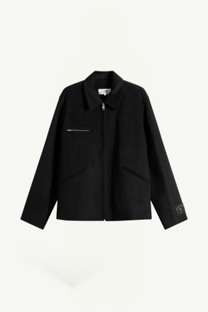 Black zip-front jacket with a stand collar, single chest zip pocket, and angled side pockets; tag visible on the left sleeve cuff edge for branding.