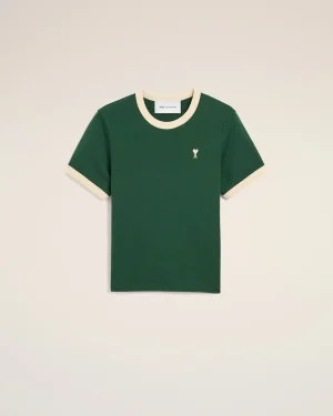 Green crew-neck t-shirt with cream collar and sleeve cuffs, small white heart with an X embroidery on the left chest.