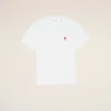 White T-shirt with a small red heart and letter 'A' emblem on the left chest, laid on a pale beige background.