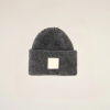 Dark gray knit beanie with a folded cuff and a small white square logo patch on the front.