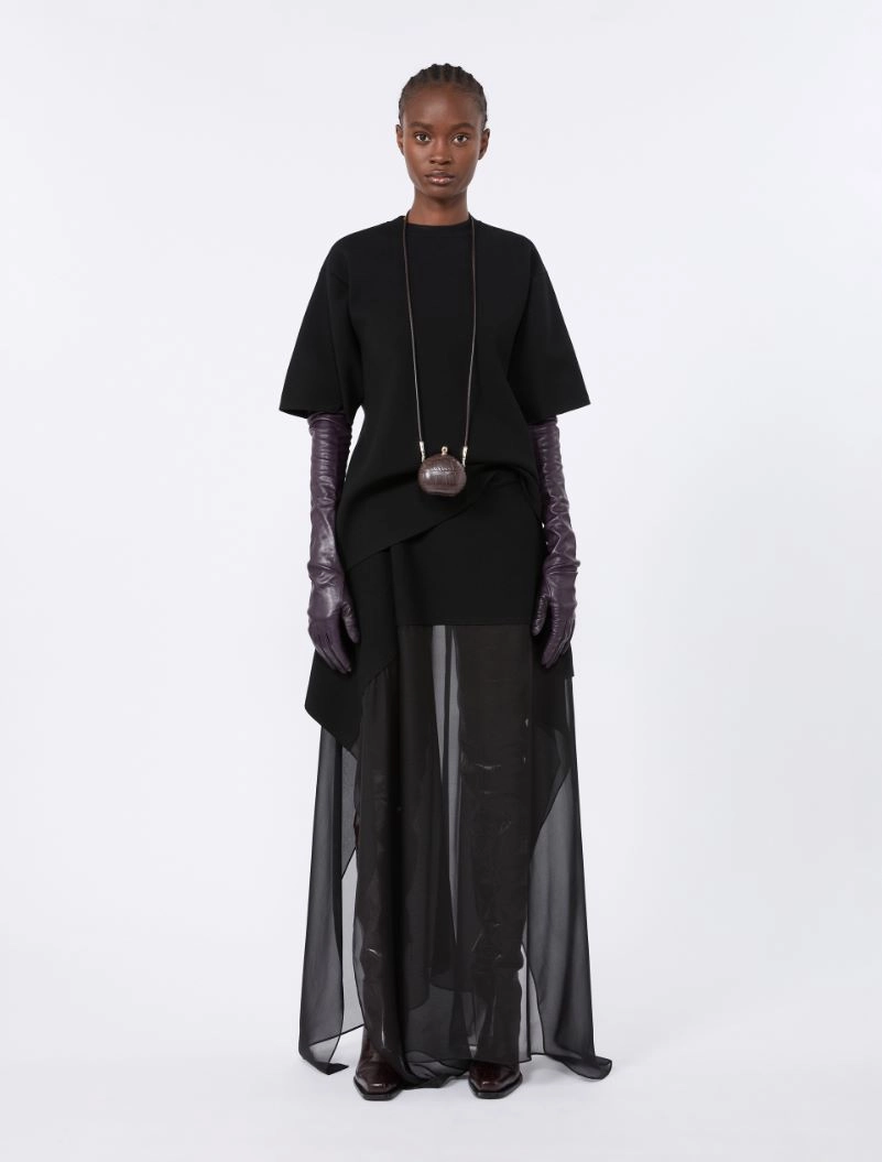 IMG_3701 - New Trend Model wearing a black oversized top, sheer floor-length skirt, purple gloves, and a small brown pendant bag on a long chain.