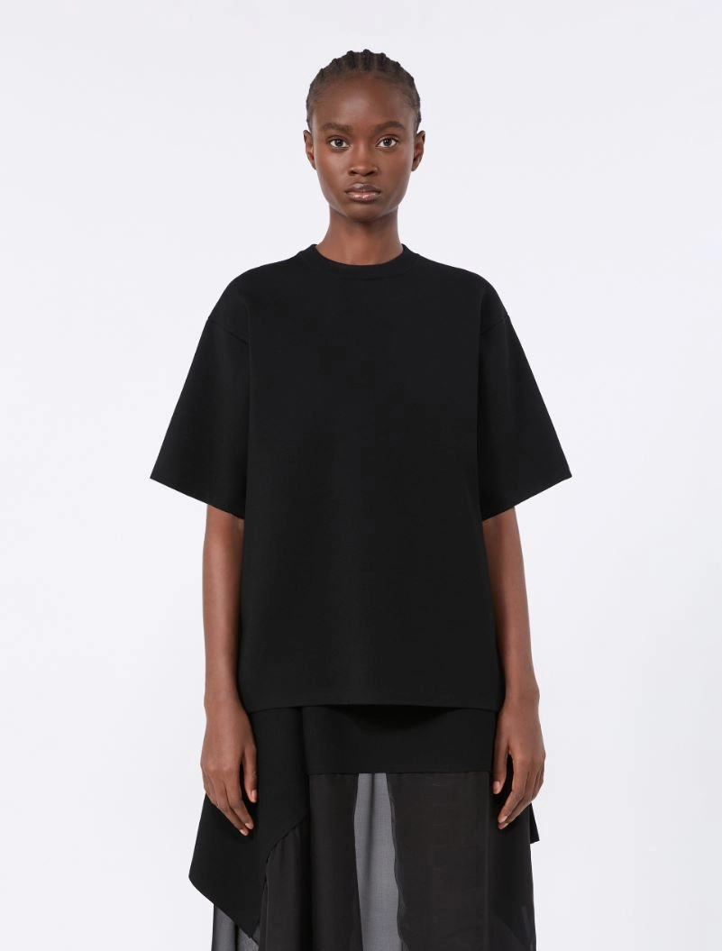 IMG_3702 - New Trend Model wearing an oversized black short-sleeve top over a layered black skirt with sheer panels.