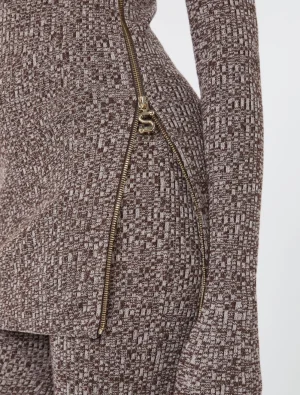 Close-up of a brown textured knit garment with a gold zipper and an S-shaped zipper pull.