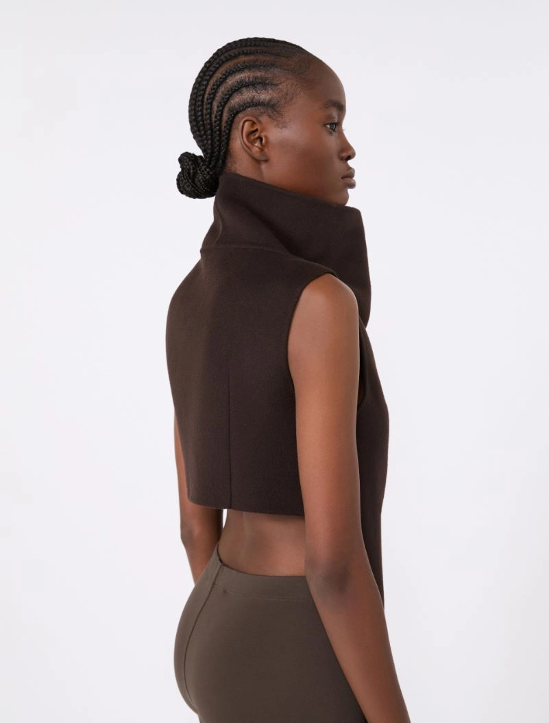 IMG_3718 - New Trend Side profile of a woman wearing a dark brown sleeveless cropped top with a high neck collar, against a light background.
