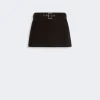 Black mini skirt with a matching belt and silver buckle on a light gray background.
