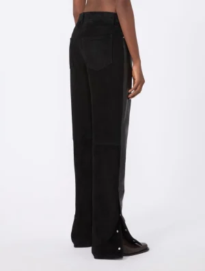 Back view of black wide-leg trousers with a rear patch pocket, high waist, and snap-button vent at the hem.