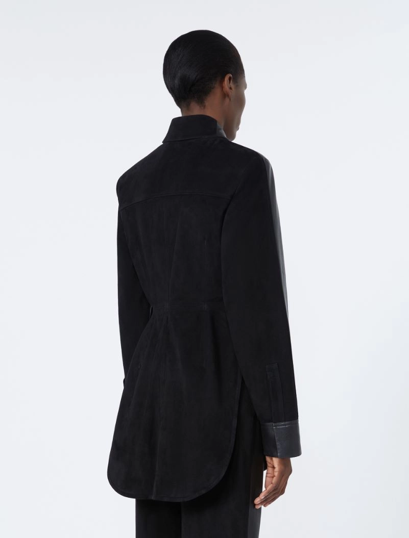 IMG_3763 - New Trend Back view of a person wearing a long black belted coat with a curved hem, seen from behind.