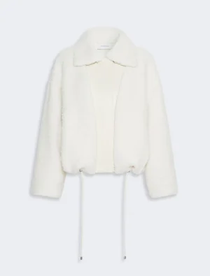 White faux-sherpa jacket with a wide collar and drawstrings, cropped length for a cozy, oversized look