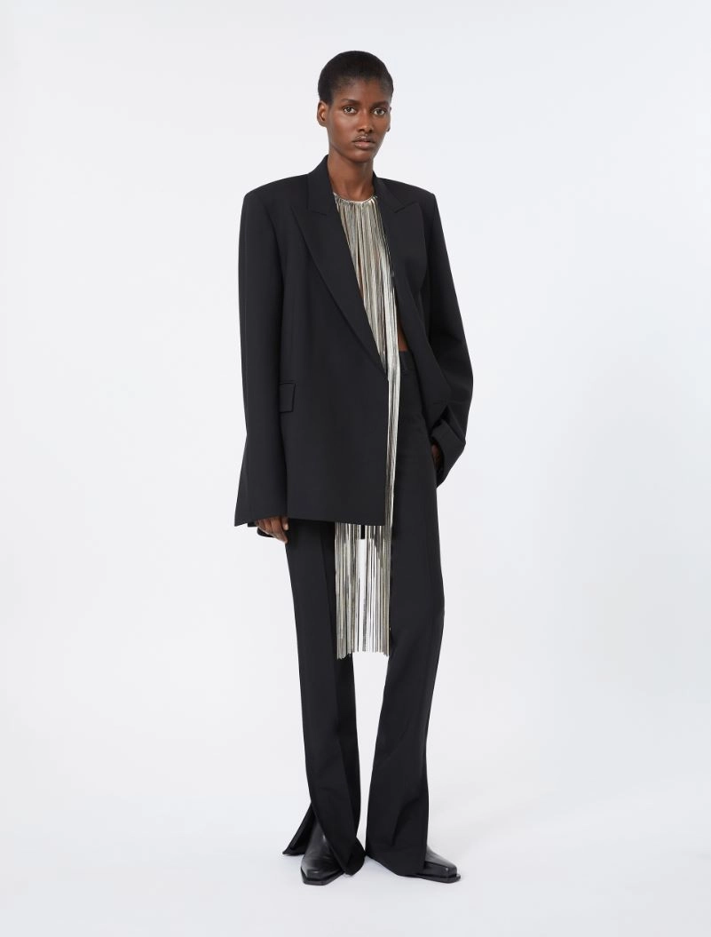 IMG_3796 - New Trend Model wearing an oversized black blazer over a silver-striped top with matching wide-leg pants, standing in a studio.