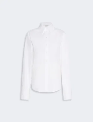 White button-down shirt with long sleeves and curved hem, on a light background (product image).