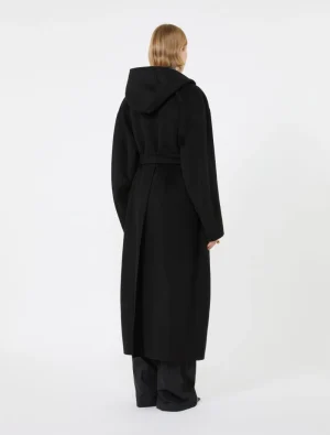 Back view of a person wearing a long black hooded coat with a belt, against a white background.