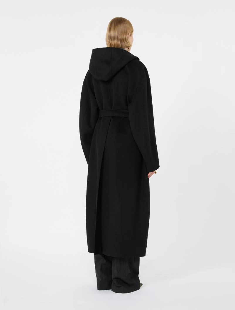 IMG_3815 - New Trend Back view of a person wearing a long black hooded coat with a belt, against a white background.