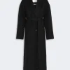 IMG_3818 - New Trend Long black wool coat with a self-tabric belt and wide lapels against a light gray background.