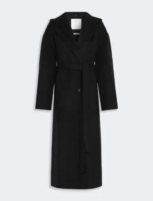Long black wool coat with a self-tabric belt and wide lapels against a light gray background.