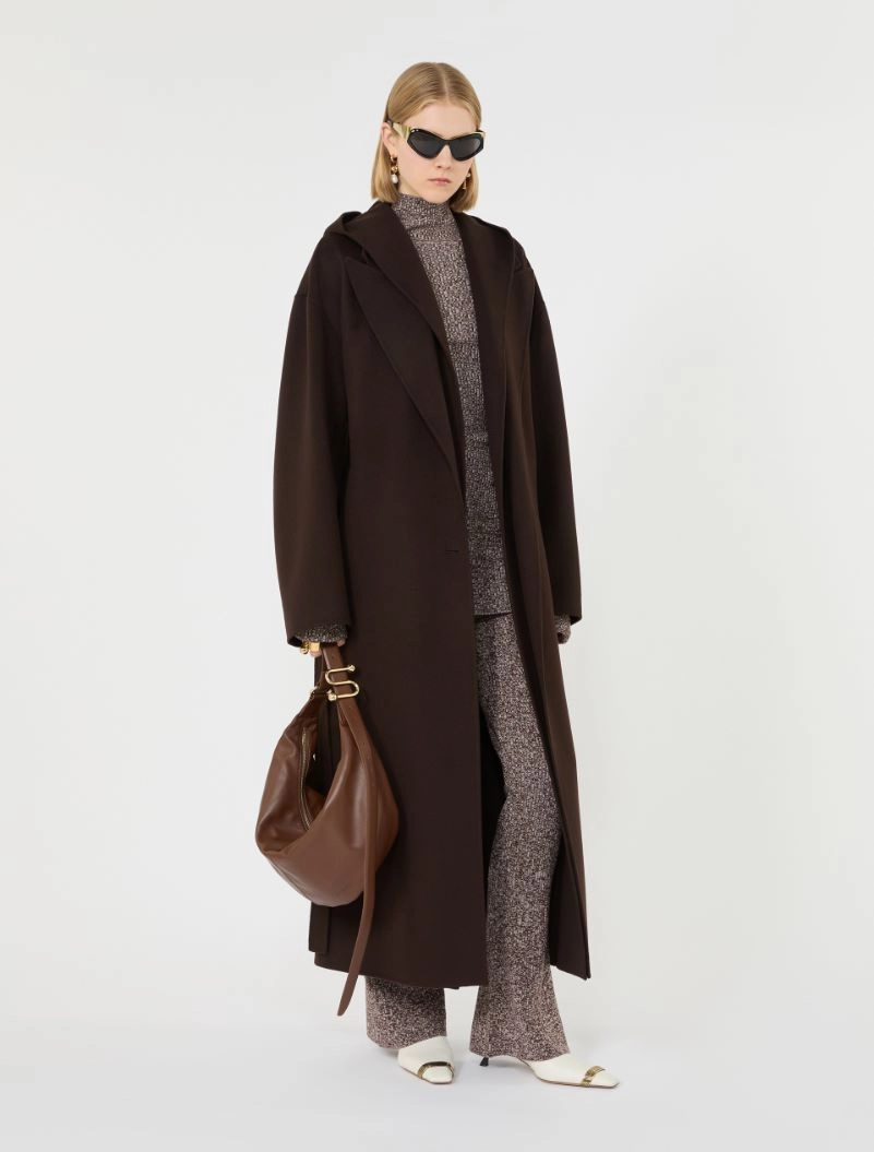 IMG_3819 - New Trend Model wearing a long dark brown coat over a textured knit set, with white sandals and a brown bag, plus black sunglasses.