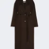 IMG_3824 - New Trend Long brown knee-length belted coat with wide lapels and front buttons on a pale background, showing a self-tie belt at the waist.