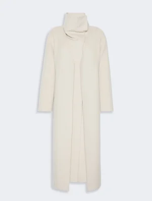 Long cream coat with a high, folded collar and an open front drape on a minimalist design.