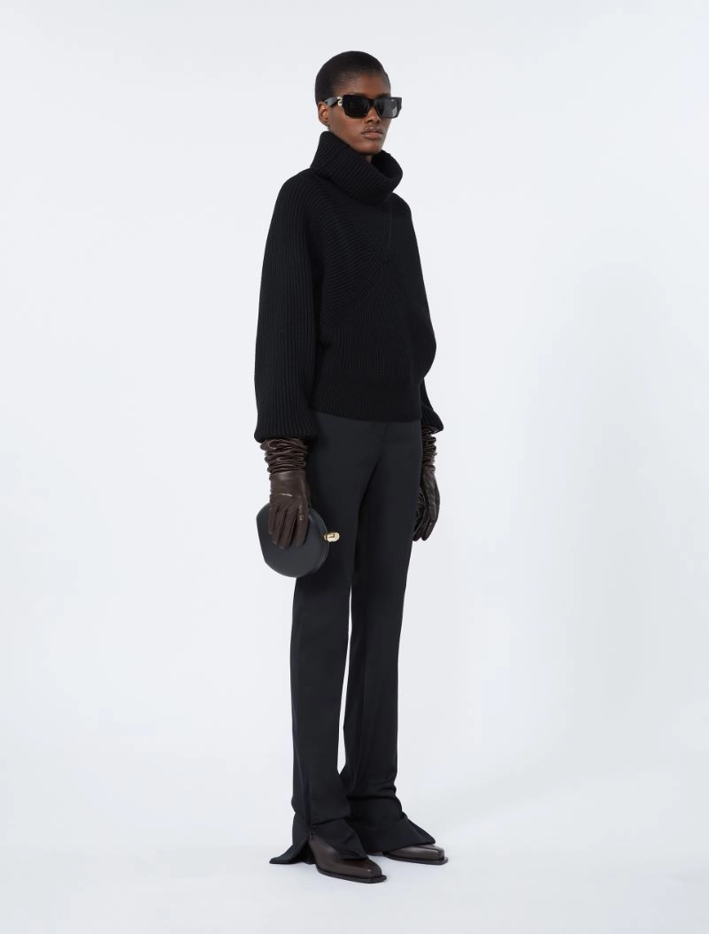 IMG_3837 - New Trend Model in an all-black ensemble: oversized turtleneck, wide-leg pants, brown gloves, sunglasses, and a small black handbag used as a fashion look.