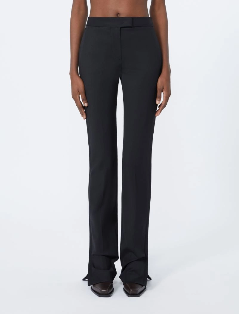 IMG_3838 - New Trend Woman wearing black tailored wide-leg pants with a flat waistband and long legs, paired with dark pointed-toe shoes.