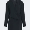 Black wrap blouse with a V-neckline and long sleeves, featuring an overlapping front panel for a draped look.