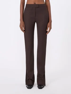 Full-length view of a person wearing dark brown, high-waisted wide-leg trousers with a matching belt, standing facing forward in black shoes.