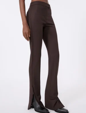 Brown wide-leg dress pants with a fitted waist and hem slits, paired with black ankle boots.