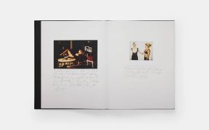 Open booklet showing two pages: left a dark indoor scene with people around a table; right a small Polaroid of two women posing, with handwritten notes beneath.