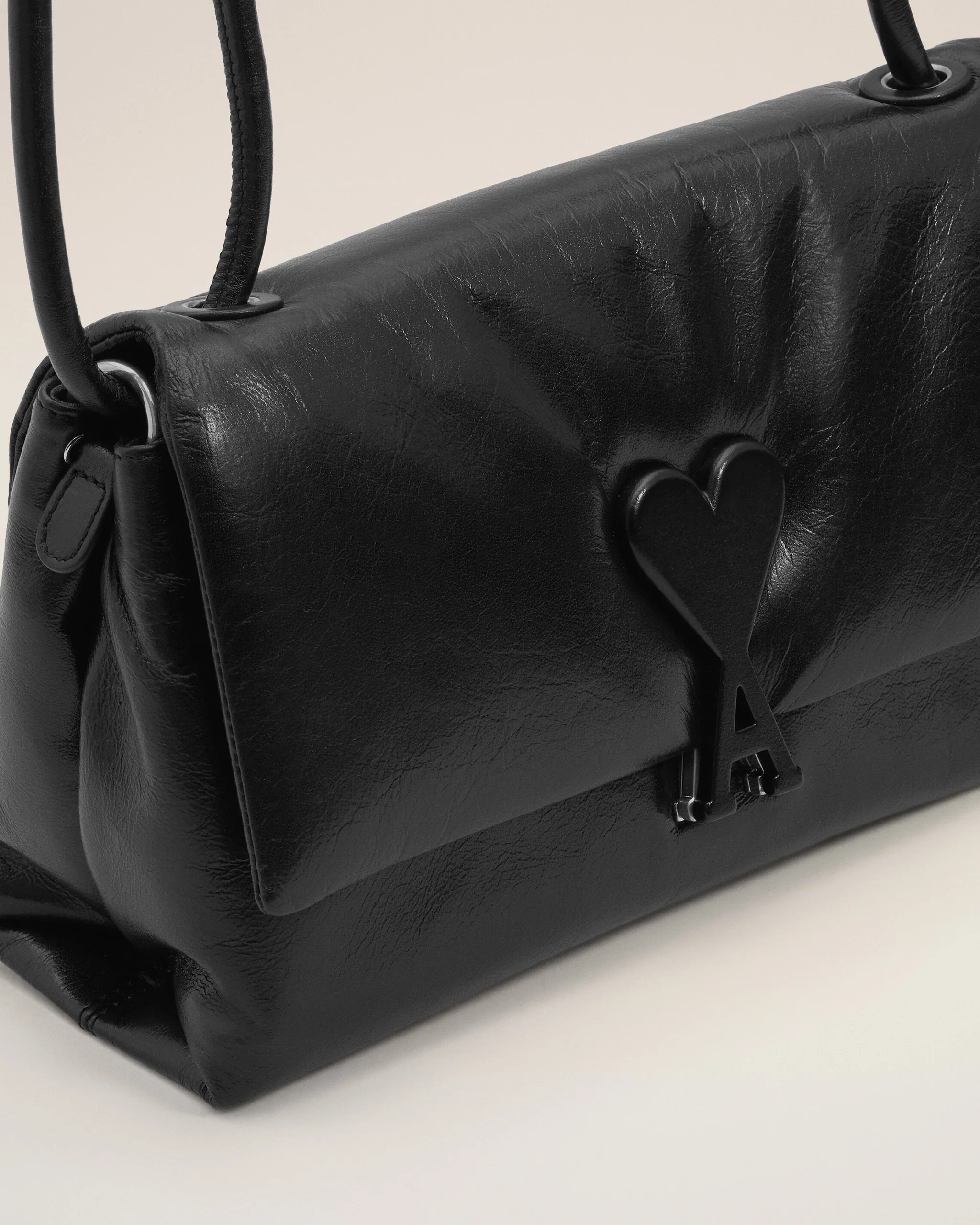 Image 111 - New Trend Close-up of a black leather handbag showing strap attachments and hardware.