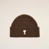 Brown knitted beanie with a small white heart graphic on the front and a folded cuff against a light background.