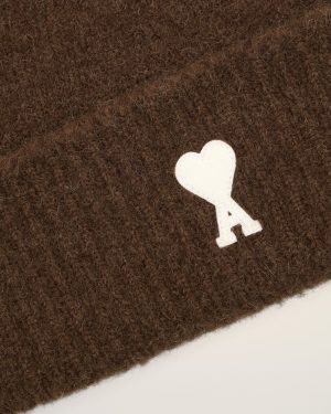 Close-up of dark brown fuzzy fabric with a white heart patch near the bottom right corner.