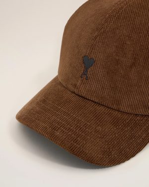 Close-up of a brown corduroy hat with a small black heart emblem on the side